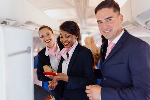 Smiling flight attendants looking at camera during disembarking