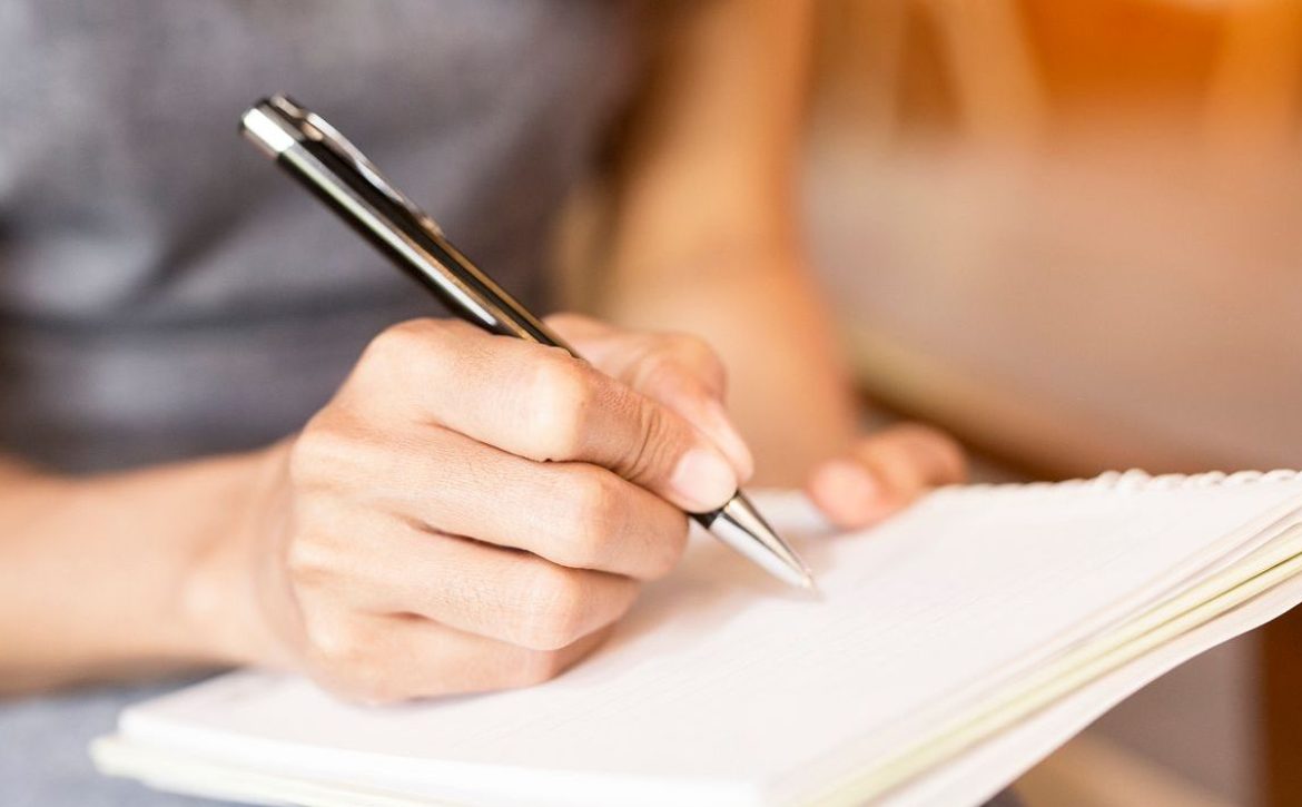 Women holding a pens writing a notebook. Recording concept