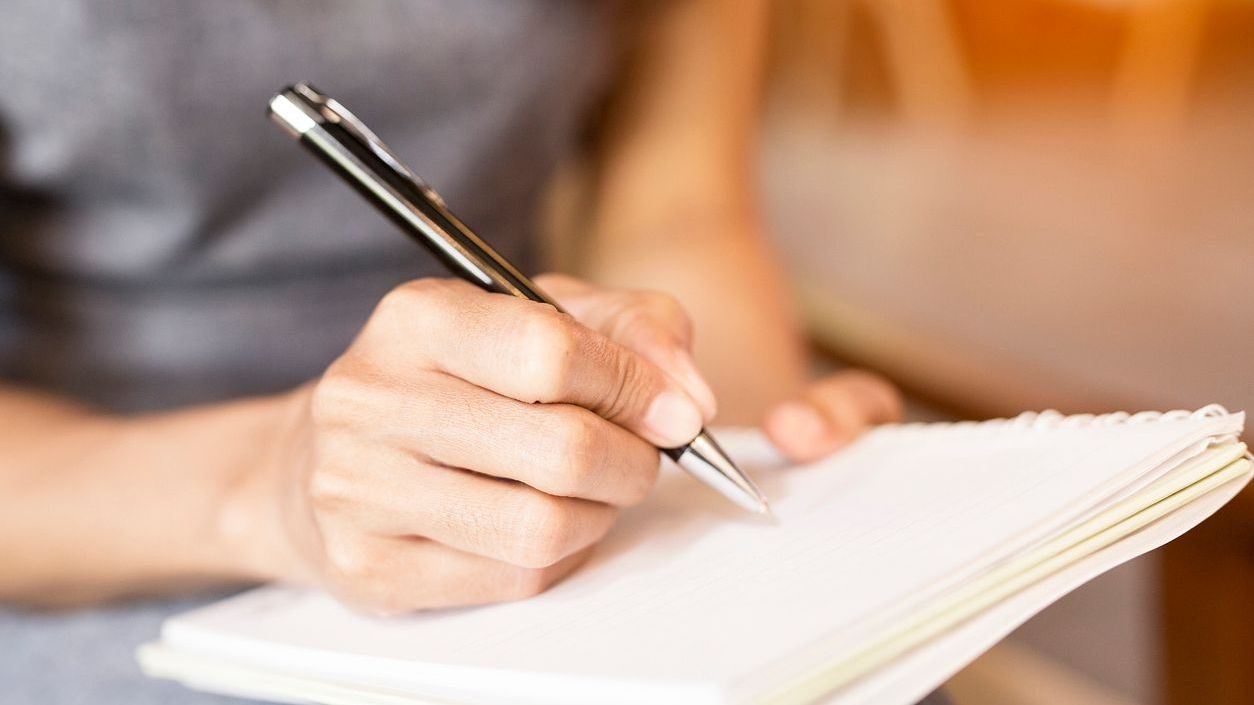 Women holding a pens writing a notebook. Recording concept