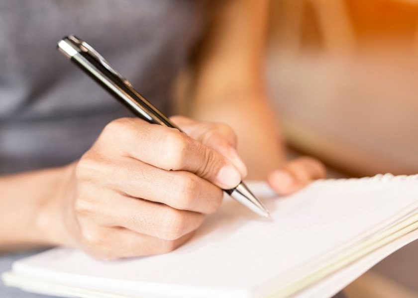 Women holding a pens writing a notebook. Recording concept